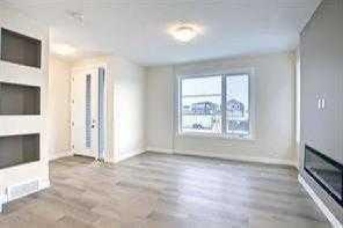 63 Lambeau Lane Se, Airdrie, AB - Indoor Photo Showing Other Room With Fireplace
