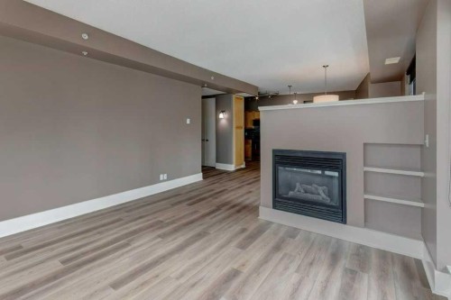701-205 Riverfront Avenue Sw, Calgary, AB - Indoor Photo Showing Living Room With Fireplace