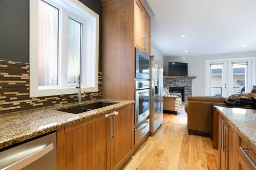 102-814 Memorial Drive Nw, Calgary, AB - Indoor Photo Showing Kitchen With Fireplace With Double Sink