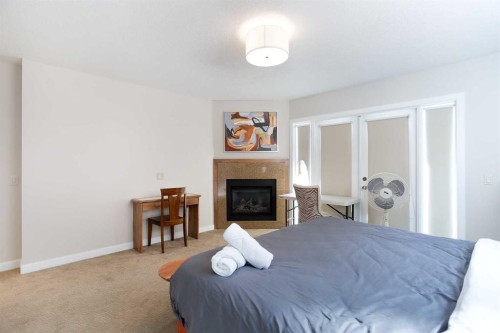102-814 Memorial Drive Nw, Calgary, AB - Indoor Photo Showing Bedroom With Fireplace