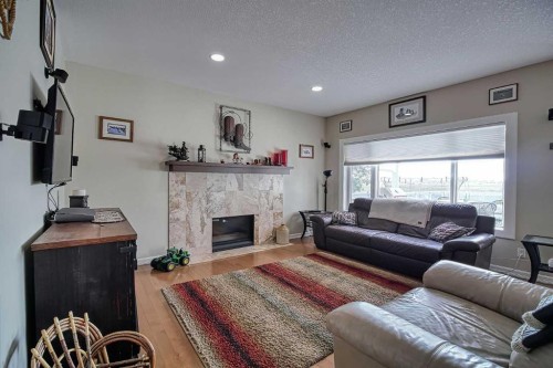 409 9 Street, Beiseker, AB - Indoor Photo Showing Living Room With Fireplace