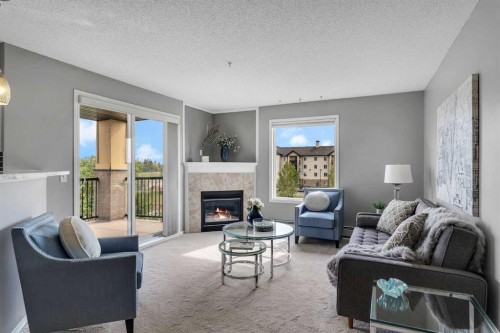 8328-304 Mackenzie Way Sw, Airdrie, AB - Indoor Photo Showing Living Room With Fireplace