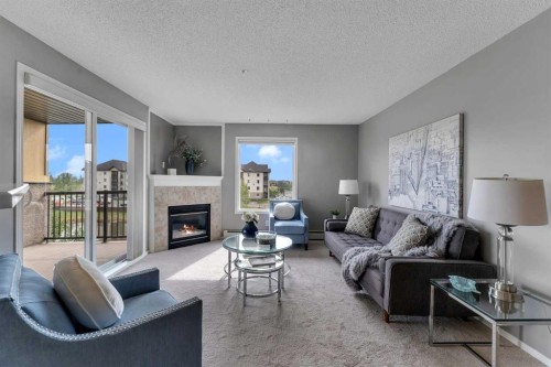 8328-304 Mackenzie Way Sw, Airdrie, AB - Indoor Photo Showing Living Room With Fireplace