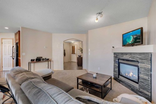 100 Covecreek Close Ne, Calgary, AB - Indoor Photo Showing Living Room With Fireplace