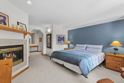 18 Juniper Ridge, Canmore, AB - Indoor Photo Showing Bedroom With Fireplace