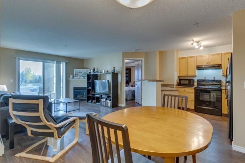 2205-2518 Fish Creek Boulevard Sw, Calgary, AB - Indoor Photo Showing Dining Room With Fireplace