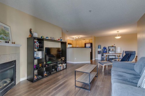 2205-2518 Fish Creek Boulevard Sw, Calgary, AB - Indoor Photo Showing Living Room With Fireplace