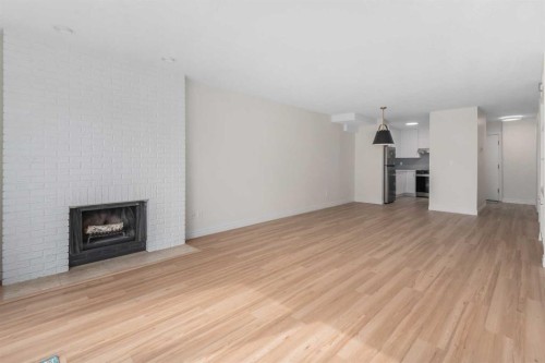 202-611 67 Avenue Sw, Calgary, AB - Indoor Photo Showing Living Room With Fireplace
