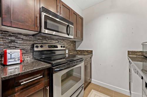 2212-403 Mackenzie Way Sw, Airdrie, AB - Indoor Photo Showing Kitchen