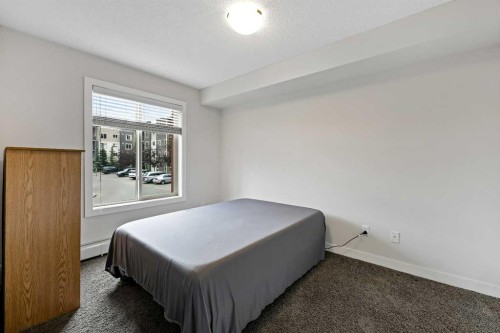 2212-403 Mackenzie Way Sw, Airdrie, AB - Indoor Photo Showing Bedroom