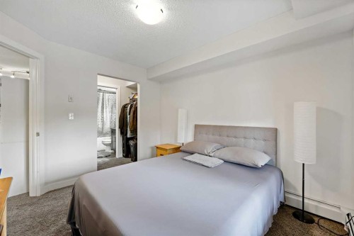 2212-403 Mackenzie Way Sw, Airdrie, AB - Indoor Photo Showing Bedroom