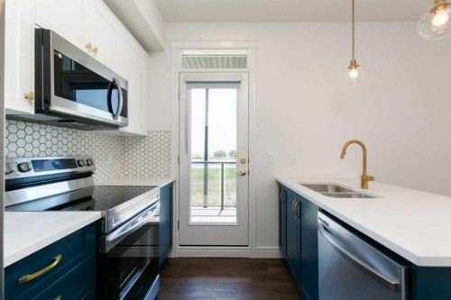 209-414 Seton Passage Se, Calgary, AB - Indoor Photo Showing Kitchen With Stainless Steel Kitchen With Double Sink With Upgraded Kitchen