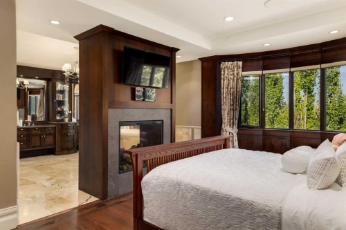 4 Aspen Ridge Bay Sw, Calgary, AB - Indoor Photo Showing Bedroom With Fireplace