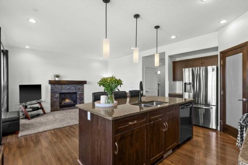 195 Hillcrest Circle Sw, Airdrie, AB - Indoor Photo Showing Kitchen With Fireplace With Double Sink With Upgraded Kitchen