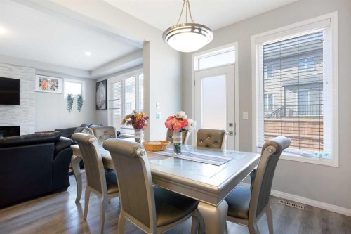 158 Osborne Common Sw, Airdrie, AB - Indoor Photo Showing Dining Room With Fireplace