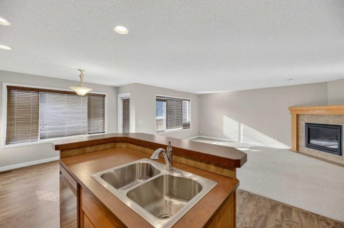 332 Sagewood Landing Sw, Airdrie, AB - Indoor Photo Showing Kitchen With Fireplace With Double Sink