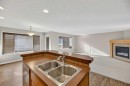 332 Sagewood Landing Sw, Airdrie, AB  - Indoor Photo Showing Kitchen With Fireplace With Double Sink 