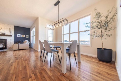 27 Sunset Park, Cochrane, AB - Indoor Photo Showing Dining Room With Fireplace
