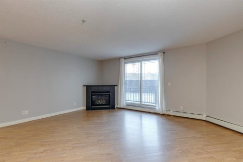 107-2440 34 Avenue Sw, Calgary, AB - Indoor Photo Showing Living Room With Fireplace
