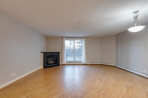 107-2440 34 Avenue Sw, Calgary, AB - Indoor Photo Showing Other Room With Fireplace
