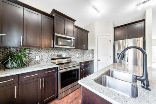 160 Sunset Point, Cochrane, AB - Indoor Photo Showing Kitchen With Stainless Steel Kitchen With Double Sink With Upgraded Kitchen