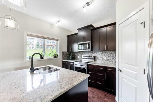 160 Sunset Point, Cochrane, AB - Indoor Photo Showing Kitchen With Double Sink With Upgraded Kitchen
