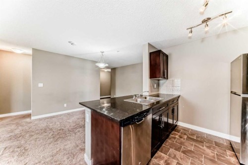 8201-403 Mackenzie Way Sw, Airdrie, AB - Indoor Photo Showing Kitchen With Double Sink