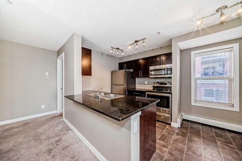 8201-403 Mackenzie Way Sw, Airdrie, AB - Indoor Photo Showing Kitchen With Stainless Steel Kitchen With Double Sink