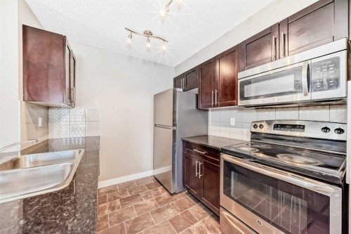 8201-403 Mackenzie Way Sw, Airdrie, AB - Indoor Photo Showing Kitchen With Double Sink