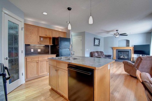 209 Sagewood Place Sw, Airdrie, AB - Indoor Photo Showing Kitchen With Fireplace With Double Sink