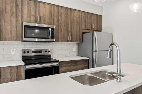 213-660 Shawnee Square Sw, Calgary, AB - Indoor Photo Showing Kitchen With Stainless Steel Kitchen With Double Sink