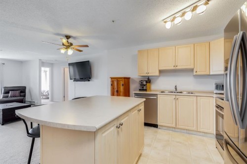 7308-304 Mackenzie Way Sw, Airdrie, AB - Indoor Photo Showing Kitchen With Double Sink