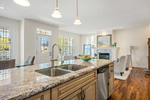 24 Ypres Mews Sw, Calgary, AB - Indoor Photo Showing Kitchen With Fireplace With Double Sink