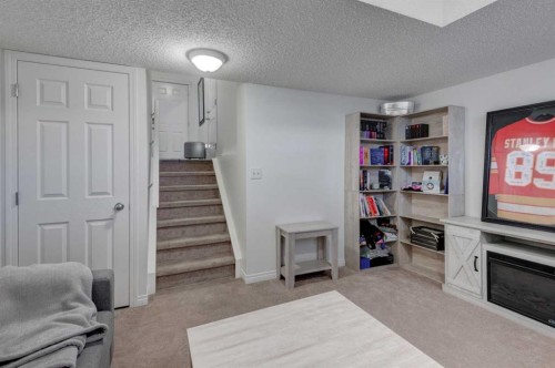 219 Copperfield Lane Se, Calgary, AB - Indoor Photo Showing Other Room With Fireplace