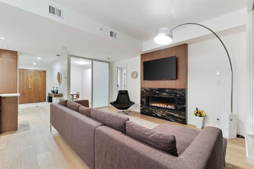 104-128 Waterfront Court Sw, Calgary, AB - Indoor Photo Showing Living Room With Fireplace