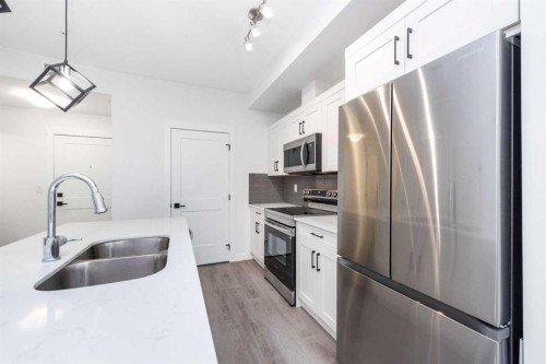 1105-200 Seton Circle Se, Calgary, AB - Indoor Photo Showing Kitchen With Stainless Steel Kitchen With Double Sink
