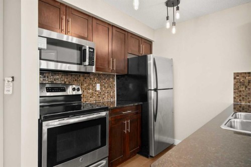 3309-403 Mackenzie Way Sw, Airdrie, AB - Indoor Photo Showing Kitchen With Stainless Steel Kitchen With Double Sink