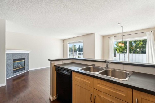 73 Rocky Ridge Heath Nw, Calgary, AB - Indoor Photo Showing Kitchen With Fireplace With Double Sink