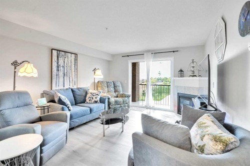 6211-304 Mackenzie Way Sw, Airdrie, AB - Indoor Photo Showing Living Room With Fireplace
