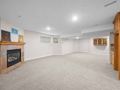 210 Evergreen Mews Sw, Calgary, AB - Indoor Photo Showing Basement With Fireplace