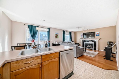 238 Bridleridge Way Sw, Calgary, AB - Indoor Photo Showing Kitchen With Fireplace With Double Sink