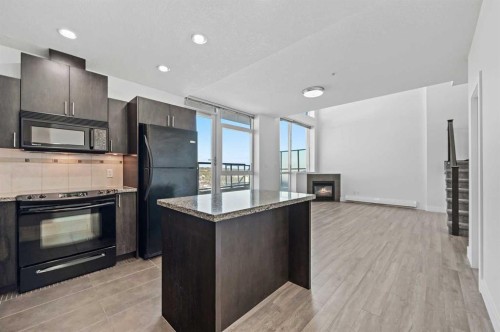 2404-77 Spruce Place Sw, Calgary, AB - Indoor Photo Showing Kitchen With Fireplace