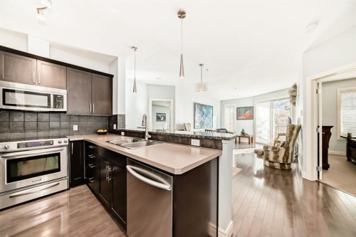 3104-15 Sunset Square, Cochrane, AB - Indoor Photo Showing Kitchen With Stainless Steel Kitchen With Double Sink With Upgraded Kitchen