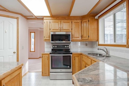 301 Riverview Green, Cochrane, AB - Indoor Photo Showing Kitchen With Double Sink