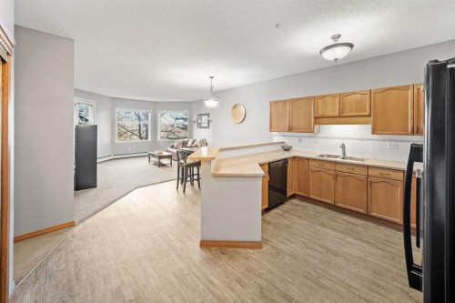 207-200 Lincoln Way Sw, Calgary, AB - Indoor Photo Showing Kitchen With Double Sink