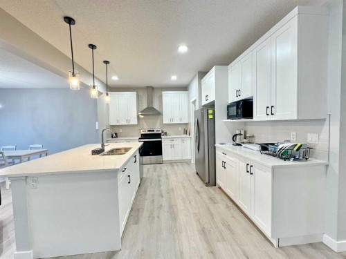14 Sundown Close, Cochrane, AB - Indoor Photo Showing Kitchen With Double Sink With Upgraded Kitchen