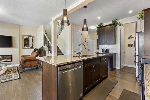 340 Lawthorn Way Se, Airdrie, AB - Indoor Photo Showing Kitchen With Fireplace With Double Sink With Upgraded Kitchen