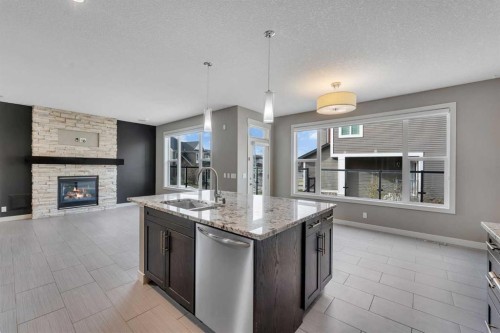 204 Sunset View, Cochrane, AB - Indoor Photo Showing Kitchen With Fireplace With Double Sink