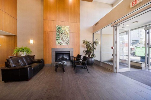 707-77 Spruce Place Sw, Calgary, AB - Indoor With Fireplace