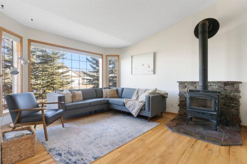179 Quigley Drive, Cochrane, AB - Indoor Photo Showing Living Room With Fireplace